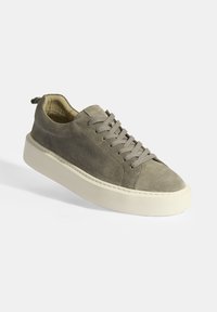 Grey suede sneakers with a thick white rubber sole, round toe, and lace-up design featuring six eyelets and a rear pull tab.
