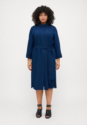Navy blue button-up dress with white vertical stripes, long sleeves, a belt at the waist, and a knee-length hem. Paired with black heeled sandals.