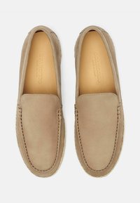 Beige ruskindssko med rundet tå, dekorativ syning og en espadrille-inspireret, flettet jutesål. Glat tekstur hele vejen igennem.