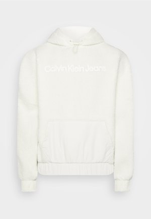 Sweat à capuche en polaire blanche avec un cordon de serrage, poche avant et bas élastiqué. Présente le logo "Calvin Klein Jeans" en blanc sur la poitrine.