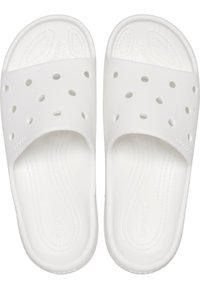 Des sandales blanches en matériau doux et texturé avec des trous de ventilation. Semelle intérieure moulée et semelle plate pour un confort optimal et une facilité d'enfilage.