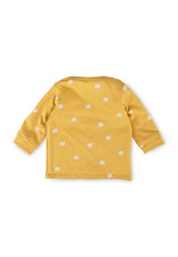 Gelbes Langarmshirt mit rundem Ausschnitt, das ein wiederholtes weißes Kronenmuster auf dem Rücken aufweist, aus weichem Baumwollmaterial hergestellt.