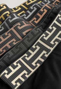 Bande din țesătură împletită în negru, gri, auriu și crem, cu modele geometrice texturate. Fiecare bandă are accente de culoare distincte.