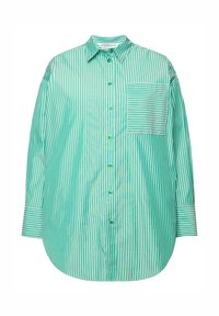 Camisa a rayas verdes y blancas con botones en la parte delantera, mangas largas y un bolsillo con parche que presenta rayas horizontales. Tejido suave, corte relajado.