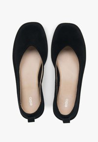 Czarne zamszowe baleriny z wyciętymi wzorami, zaokrąglonym czubkiem i miękką beżową wkładką. Posiadają mały obcas i zapięcie z tyłu, ułatwiające zakładanie.