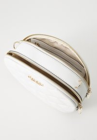 Borsa a tracolla bianca trapuntata con doppie cerniere dorate, caratterizzata da una texture liscia e un interno beige chiaro. Include uno slot per carte e un logo in tonalità oro lucido.