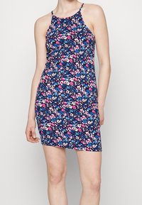 Abito floreale con sfondo blu navy, caratterizzato da fiori rosa e blu. Ha un design aderente, spalline sottili e una silhouette al ginocchio.