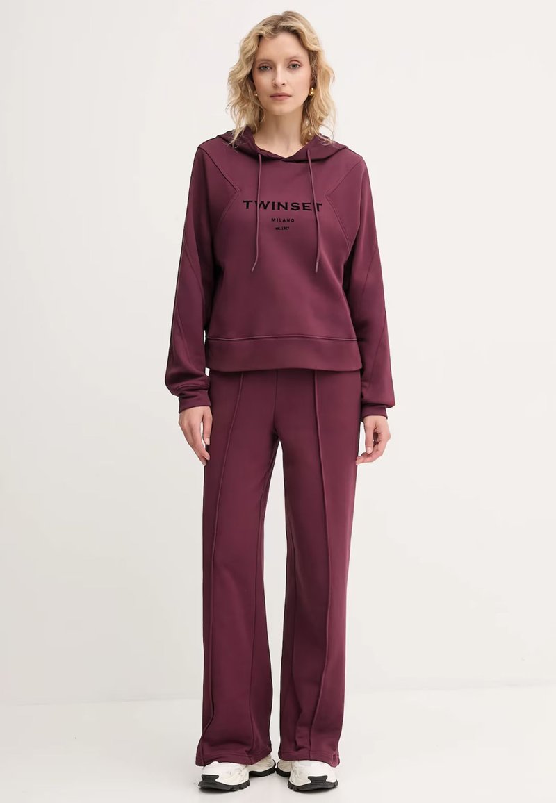 Bordový mikinový set s elastickými nohavicami, vyrobený z mäkkej tkaniny, s logom na hrudi, kapucňou so šnúrkou a priamym strihom nohavíc.