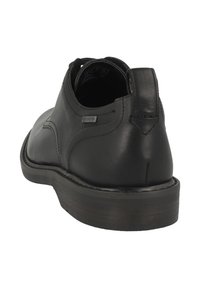 Zwarte leren schoen met een ronde neus, gladde textuur en een lage hak. Heeft een zichtbaar Gore-Tex-label bij de hak voor waterdichtheid.