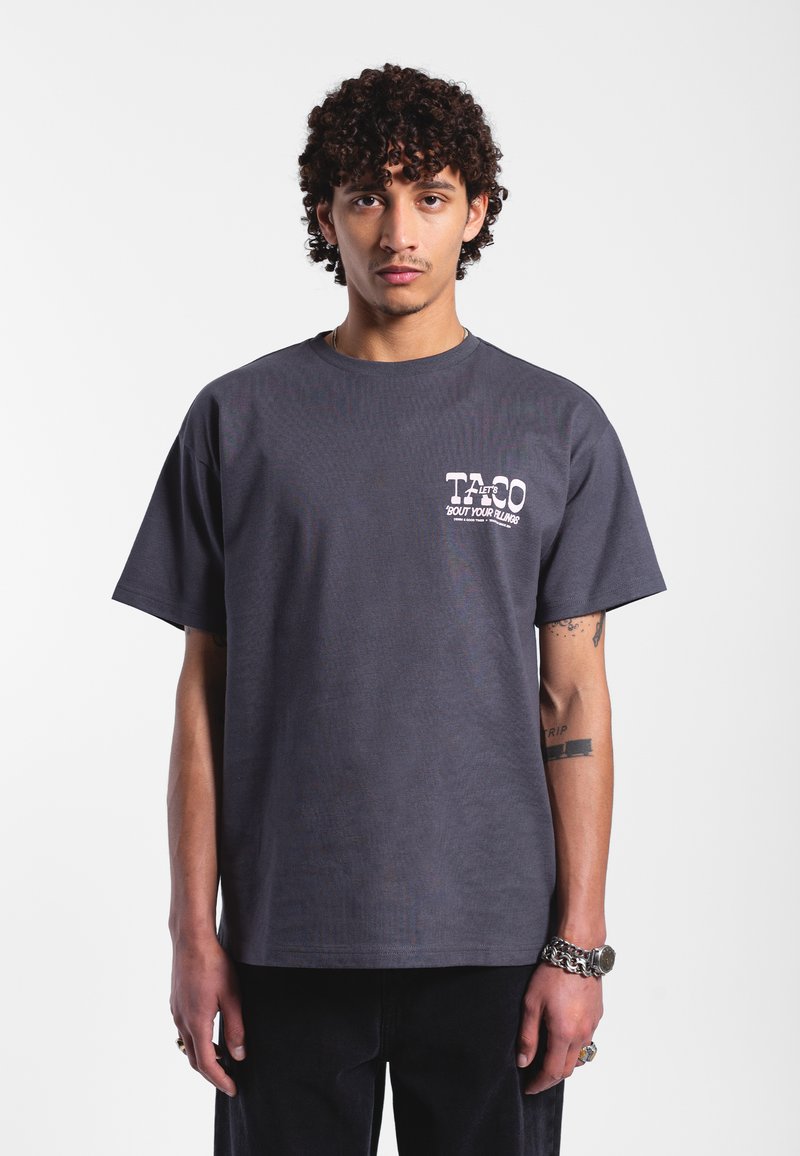 Czarnogranatowy bawełniany t-shirt z nadrukiem na lewej piersi z napisem "TACO", luźny krój, okrągły dekolt, krótkie rękawy i proste wykończenie.