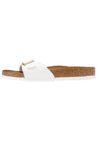 Witte flip-flop sandaal met een dikke kurken zool en een glanzende bovenste band met een gouden hardware accent. De buitenzool is voorzien van textuur voor grip.