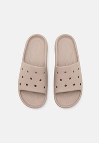 Beige gummisandal med perforeret overdel, præget logo, tekstureret sål og glat bund for bedre greb.