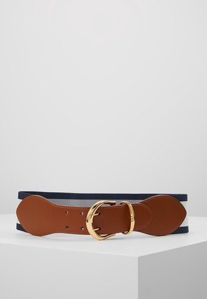 Bruine leren riem met gouden gesp en marineblauwe elastische band, tentoongesteld op een witte ondergrond tegen een effen lichte achtergrond.