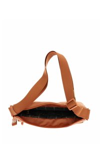 Sac à épaule en tissu marron avec une finition texturée, bandoulière réglable, fermeture éclair et poche intérieure avec doublure noire.