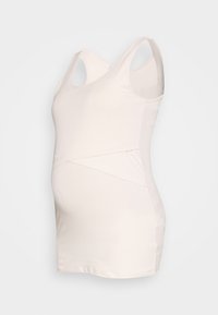 Top de maternidade em tecido leve e suave em bege claro. Apresenta um design cruzado e material elástico para conforto à volta da barriga.