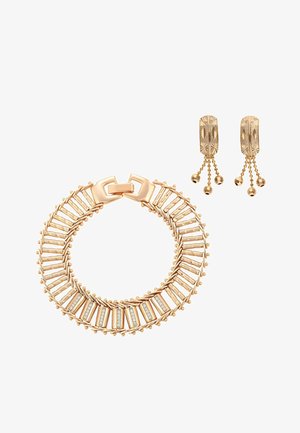 Goldenes Armband mit rechteckigen Gliedern und eingelassenen Steinen, kombiniert mit goldenen rechteckigen Ohrringen, die jeweils drei herabhängende Kugelketten aufweisen.