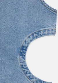 Vaaleansininen farkkukangas, jossa on pyöreä pääntie ja kuluneet reunat. Eronnee oranssin värinen näkyvä ompelu korostaa muotoa.