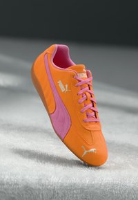 Orange und rosa Sport Schuh mit Obermaterial aus Wildleder, Gummisohle und Logo-Details. Verfügt über eine abgerundete Zehenpartie und ein Schnürsystem.