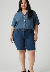 Denim-painakäytävä, keskisininen, lyhyet hihat; yhdistetty tummansiniset denimpitkät shortsit. Suuri tekstuuri, rento istuvuus ja klassinen muotoilu.