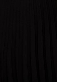 Svart veckad tyg med vertikala veck och mjuk textur; jämnt fördelade veck skapar ett enhetligt mönster och en flytande drapering.