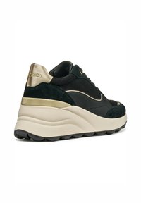 Sneaker neri e verde scuro realizzati in suede e pelle, con una spessa suola a cuneo color crema e dettagli in oro sul tallone.