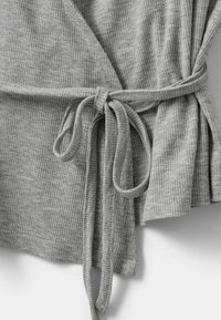 Graues, geripptes Wickeltop mit Schleife, weicher Textur und fließendem Design. Sichtbare Nähte und durchgehendes Rippmuster.