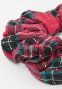 Czerwono-czarna gumka do włosów w kratę, wykonana z miękkiego, teksturowanego materiału z akcentami w kolorze teal. Charakteryzuje się marszczoną, elastyczną konstrukcją, zapewniającą pewne noszenie.