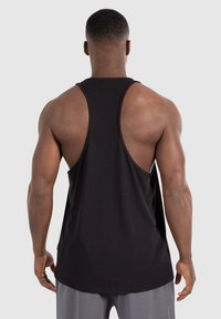 Zwarte tanktop met een racerback ontwerp, met een gladde textuur en een losse pasvorm, die de schouder- en rugdelen accentueert.
