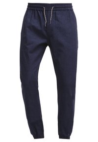 Marineblauwe casual broek met elastische tailleband, witte en blauwe trekkoorden, taps toelopende pijpen en elastische boorden.