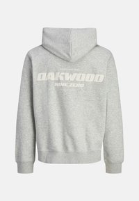 Hanorac gri cu o textură moale, având un imprimat alb mare care spune "OAKWOOD NINE.ZERO" împreună cu "Fondat în 1990" pe spate.
