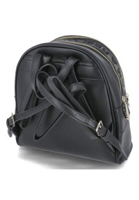 Sac à dos en cuir noir avec des accents dorés, forme incurvée, fermeture à double zip et détails de sangle superposés au dos. Texture lisse, accents minimalistes.