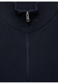 Maglione a collo alto a coste color navy con mezza cerniera, caratterizzato da un tessuto strutturato e una leggera brillantezza nel dettaglio della cerniera.