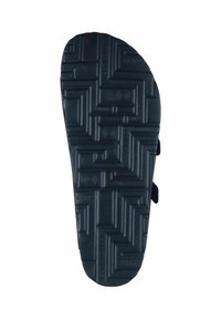 Black rubber shoe sole featuring a textured zigzag pattern and circular accents, designed for traction and durability. Two straps visible.