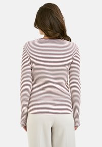 Striped long-sleeve top in cream and burgundy with a ribbed texture, featuring a round neckline and fitted silhouette.