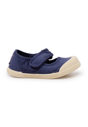Chaussure en toile navy avec un embout arrondi et une semelle en caoutchouc beige. Dotée d'une sangle en Velcro sur le cou-de-pied pour un attachement facile.