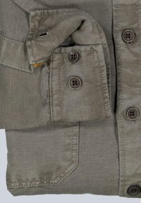 Graues Button-Up-Hemd aus strukturiertem Stoff. Verfügt über zwei Brusttaschen, braune Knöpfe und einen umgeschlagenen Kragen.