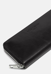 Schwarzes Lederportemonnaie mit glatter Oberfläche, ausgestattet mit einem silbernen Reißverschluss und geprägt mit dem Markennamen. Einfaches rechteckiges Design ohne Muster.