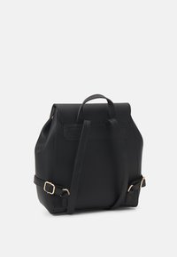 Black leather backpack with a structured shape, top handle, and adjustable straps. Features a flap closure and gold-tone hardware accents.