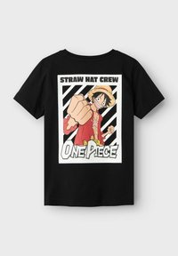 Camiseta de algodón negra con un estampado gráfico de un personaje con un sombrero de paja y vestimenta roja, con el texto "CABILDO DE SOMBRERO DE PAJA" y "One Piece".