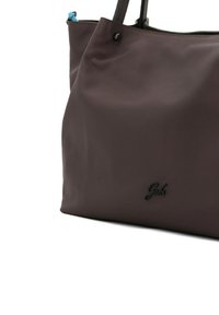 Borsa tote in pelle marrone con una texture liscia, caratterizzata da un dettaglio logo nero e accenti di cerniera blu. Manici doppi robusti per il trasporto.