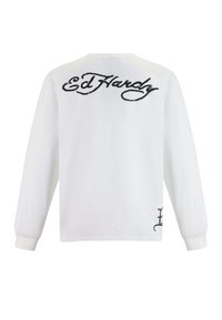 Weißes Langarmhemd mit großem schwarzem "Ed Hardy"-Logo auf der Rückseite und einem kleineren Logo-Detail an der unteren Seite.
