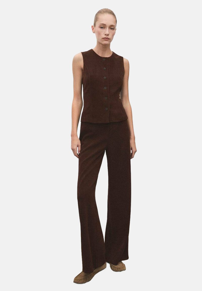 Brown corduroy vest with a round neck and button front, paired with matching wide-leg trousers. The outfit has a sleek, tailored design.