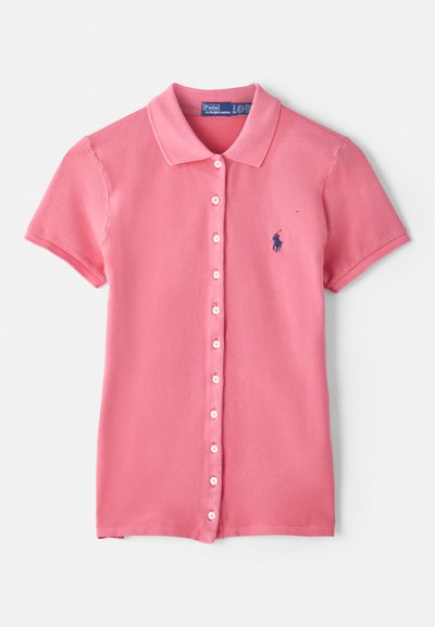 Polo-Shirt aus leicht rosa Baumwolle mit Knopfleiste, kurzen Ärmeln und einem dunkelblauen Logo, das auf der linken Brust gestickt ist.