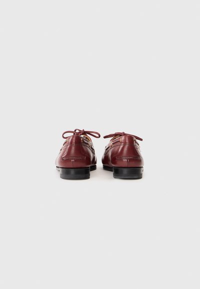 Burgundy leather shoes with laces, featuring a rounded toe and black rubber sole. Accented with stitching details on the heel and sides.