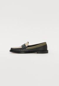 Mocassins en cuir noir et vert olive avec un bout de couleur crème. Présentent des détails cousus et une sangle texturée à l'avant.