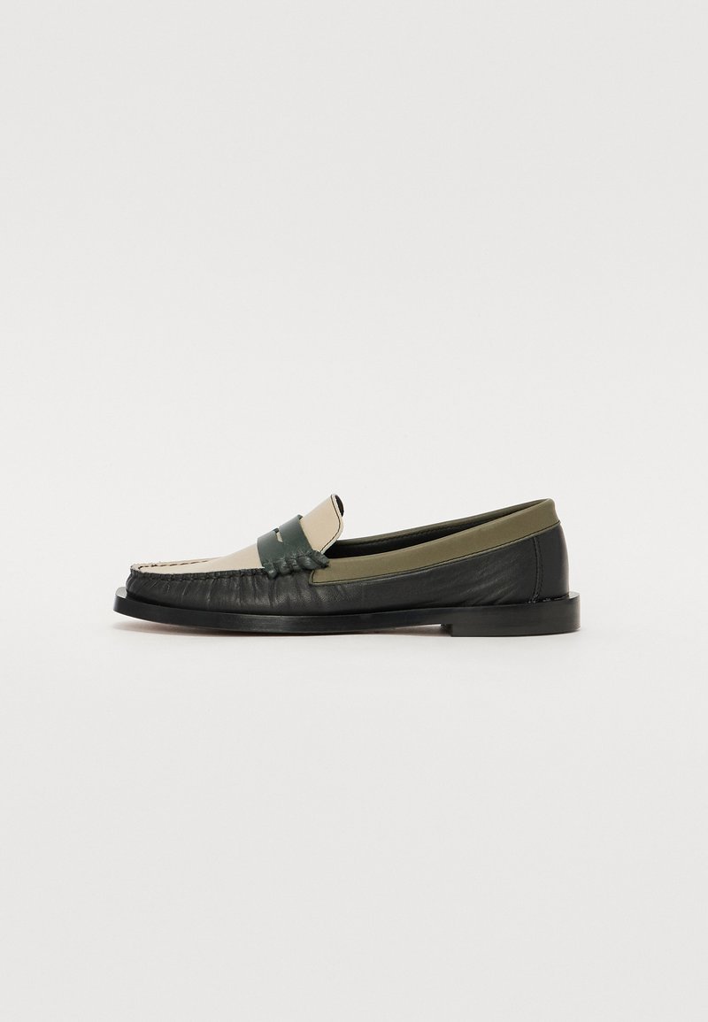 Mocassins en cuir noir et vert olive avec un bout de couleur crème. Présentent des détails cousus et une sangle texturée à l'avant.