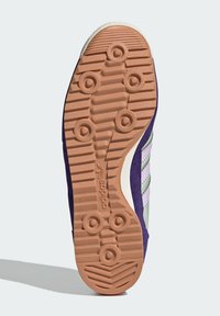 Sole obuvi Adidas s fialovým semišovým zvrškom, svetlozelenými akcentmi, textúrovanou gumovou podrážkou a kruhovými trakčnými vzormi.