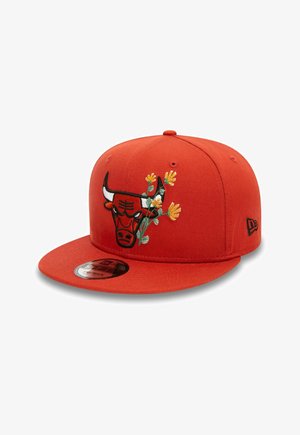 Red baseball cap with a black bull logo and yellow flowers embroidered on the front, flat brim, and black New Era logo on the side.