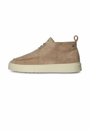 Jasnobrązowy zamszowy sneaker typu mid-top z beżową, grubą podeszwą, sznurowaniem z przodu i pętlą na pięcie na białym tle.