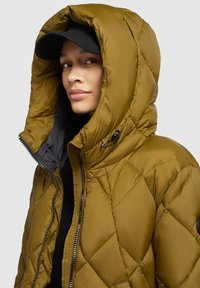 Quilted puffer jacket in olive green with a large hood, silver zipper, and black accent, featuring smooth texture and diamond pattern.